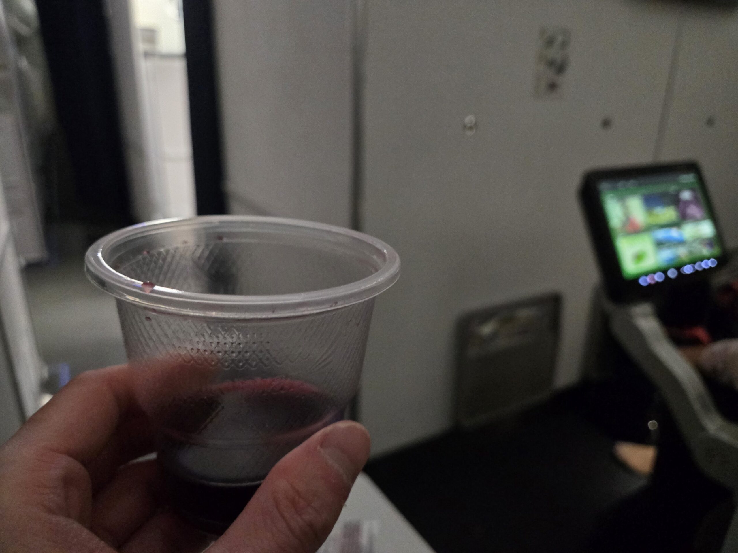 飛行機内のプラスチックカップに入った飲み物
