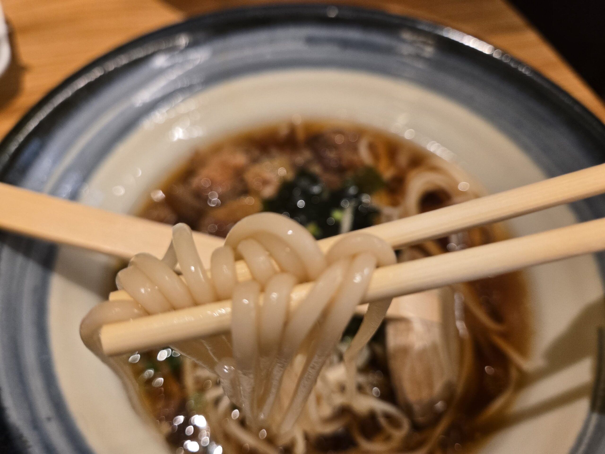 うどんの麺を箸で持ち上げる