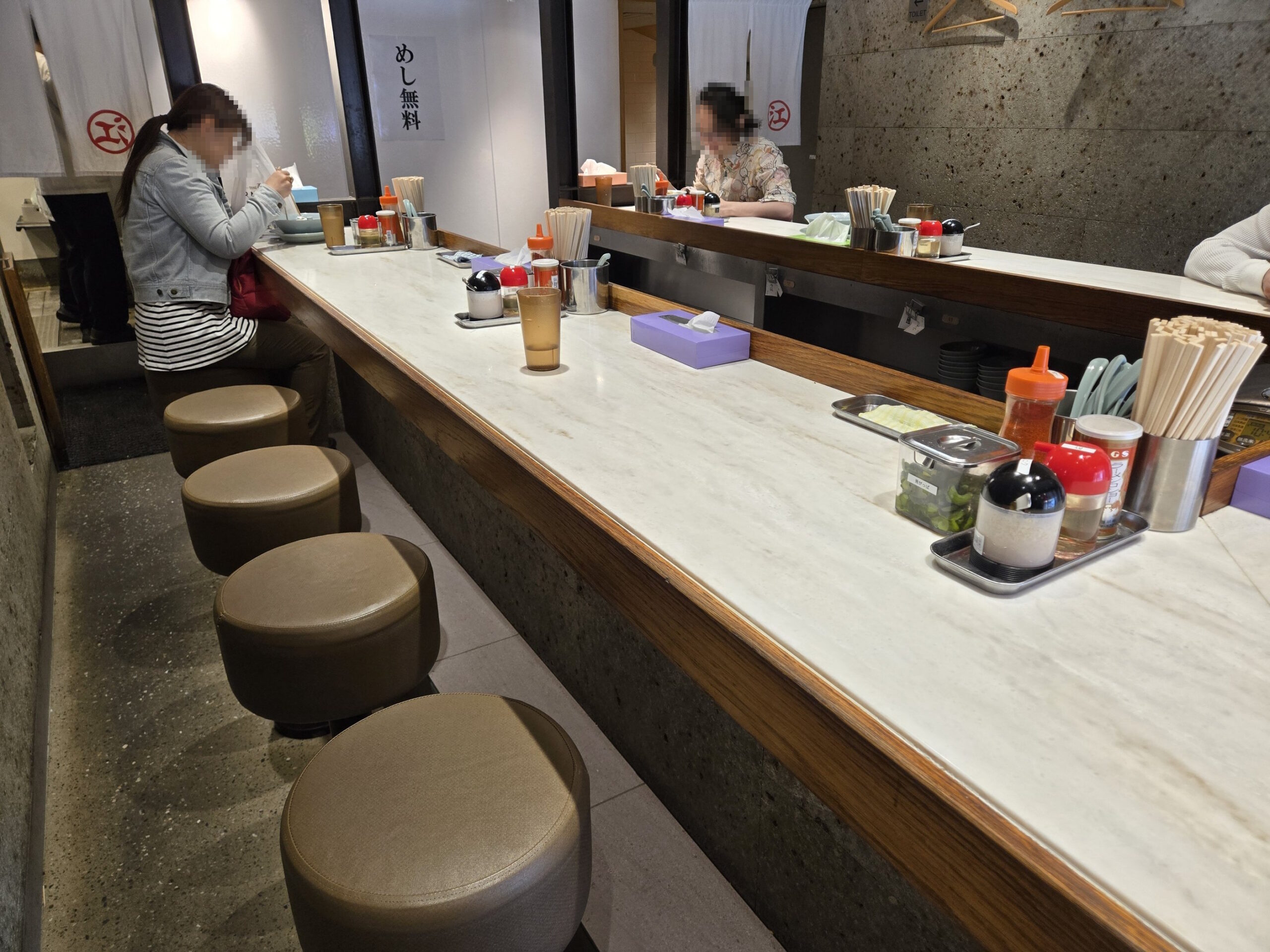 ラーメン店のカウンター席と客