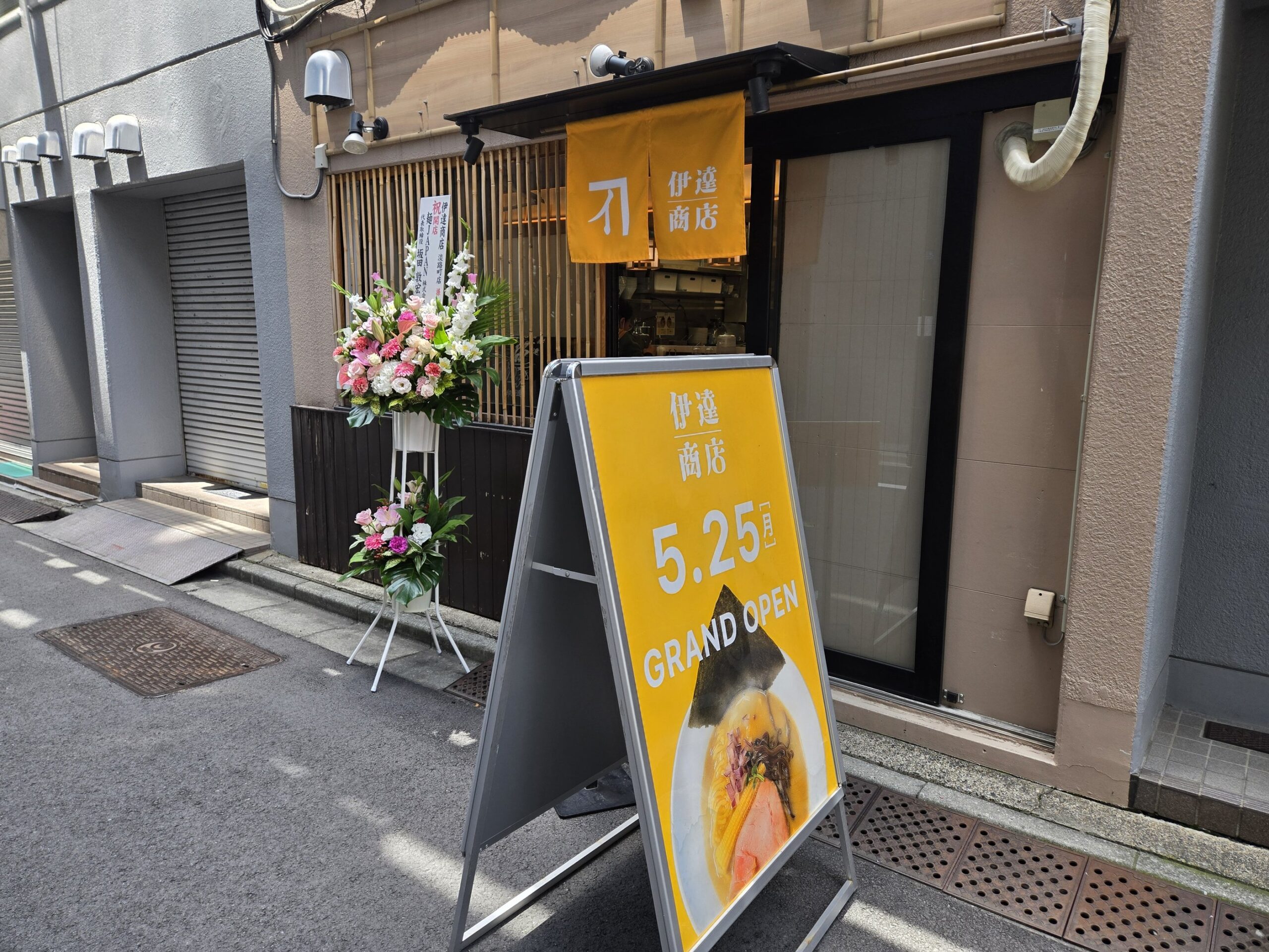伊達商店の外観と開店日を示す看板