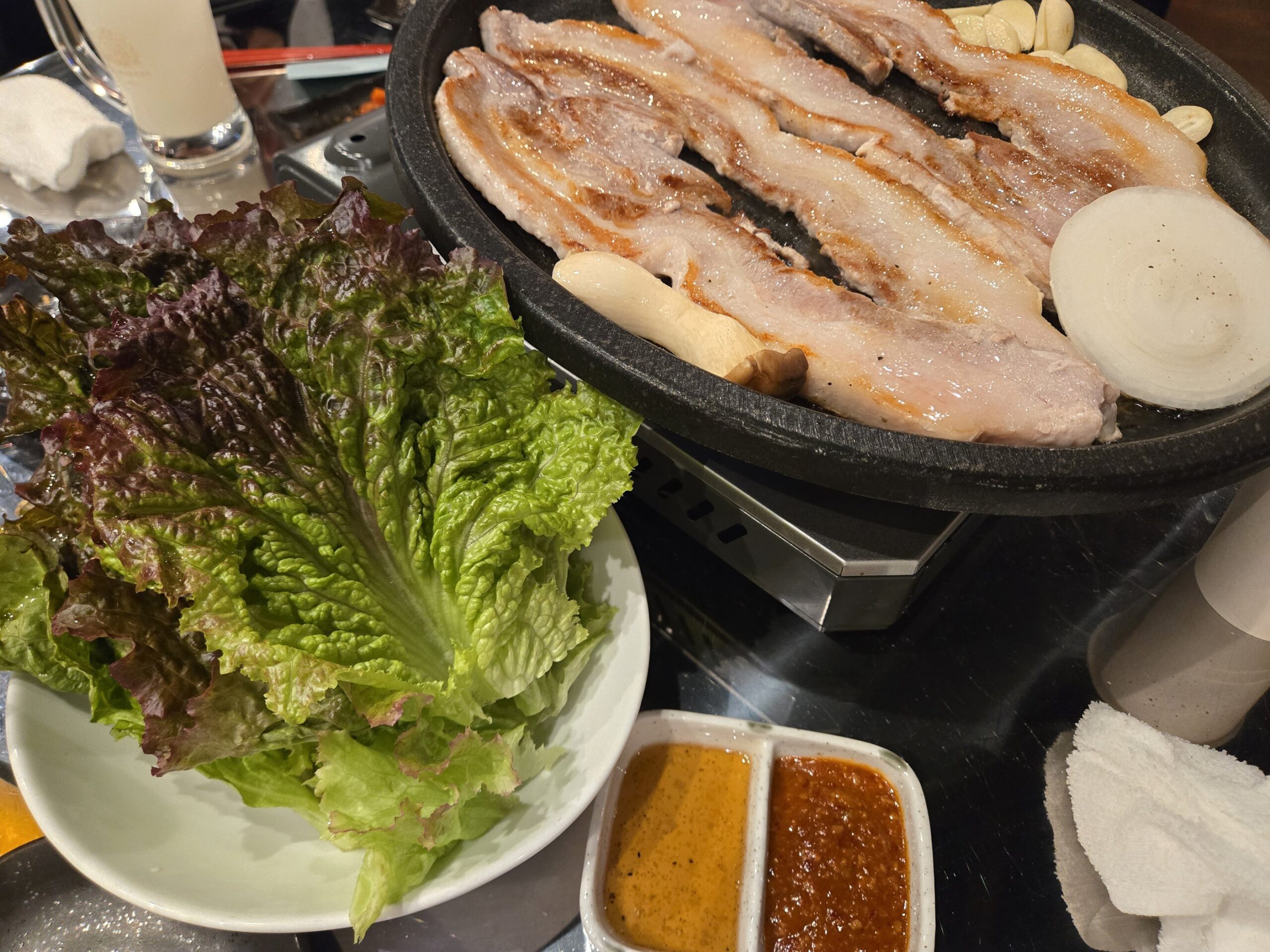 鉄板で焼かれるサムギョプサルと野菜