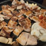 鉄板で焼かれるサムギョプサルと野菜