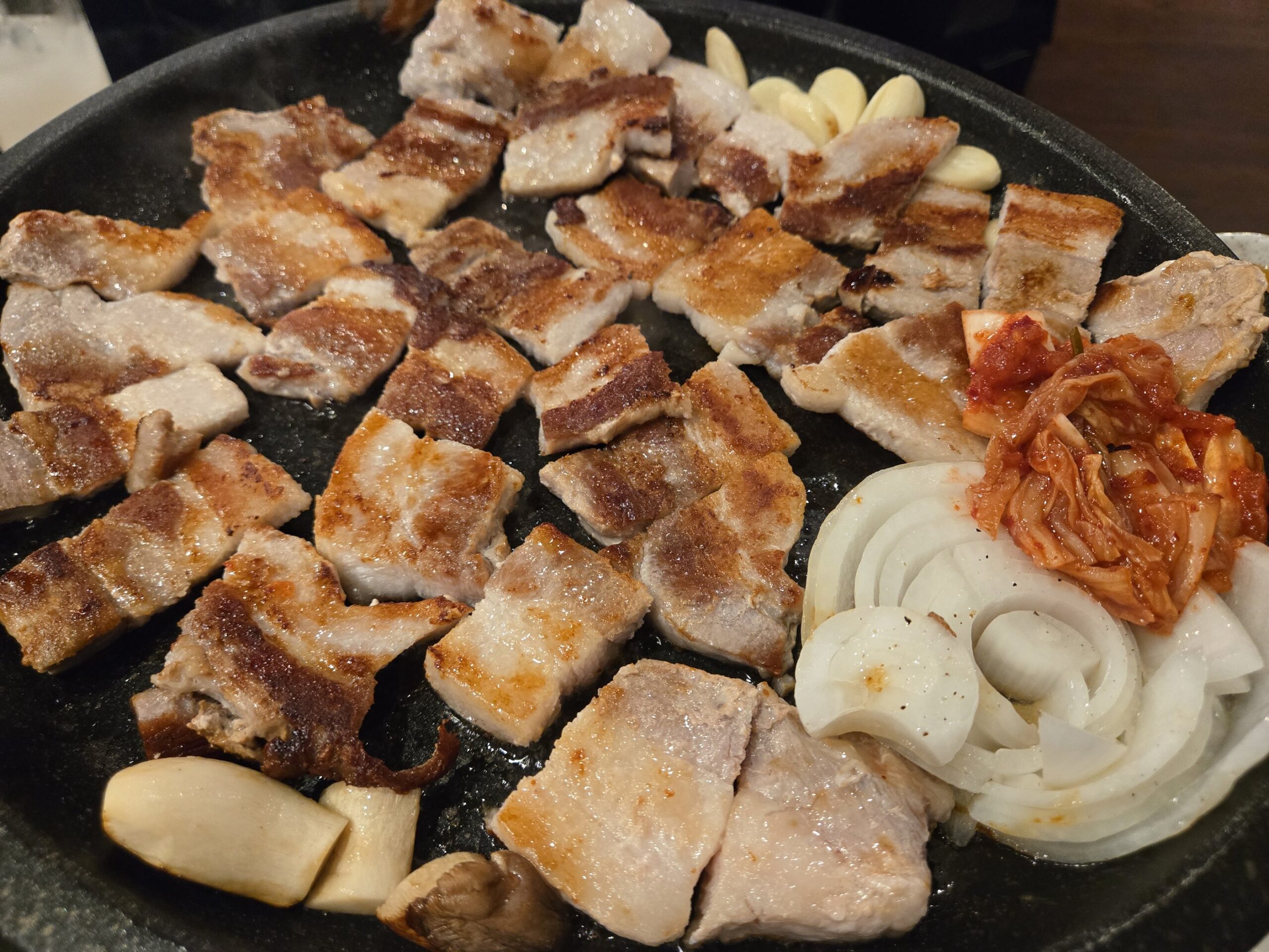 鉄板で焼かれるサムギョプサルと野菜