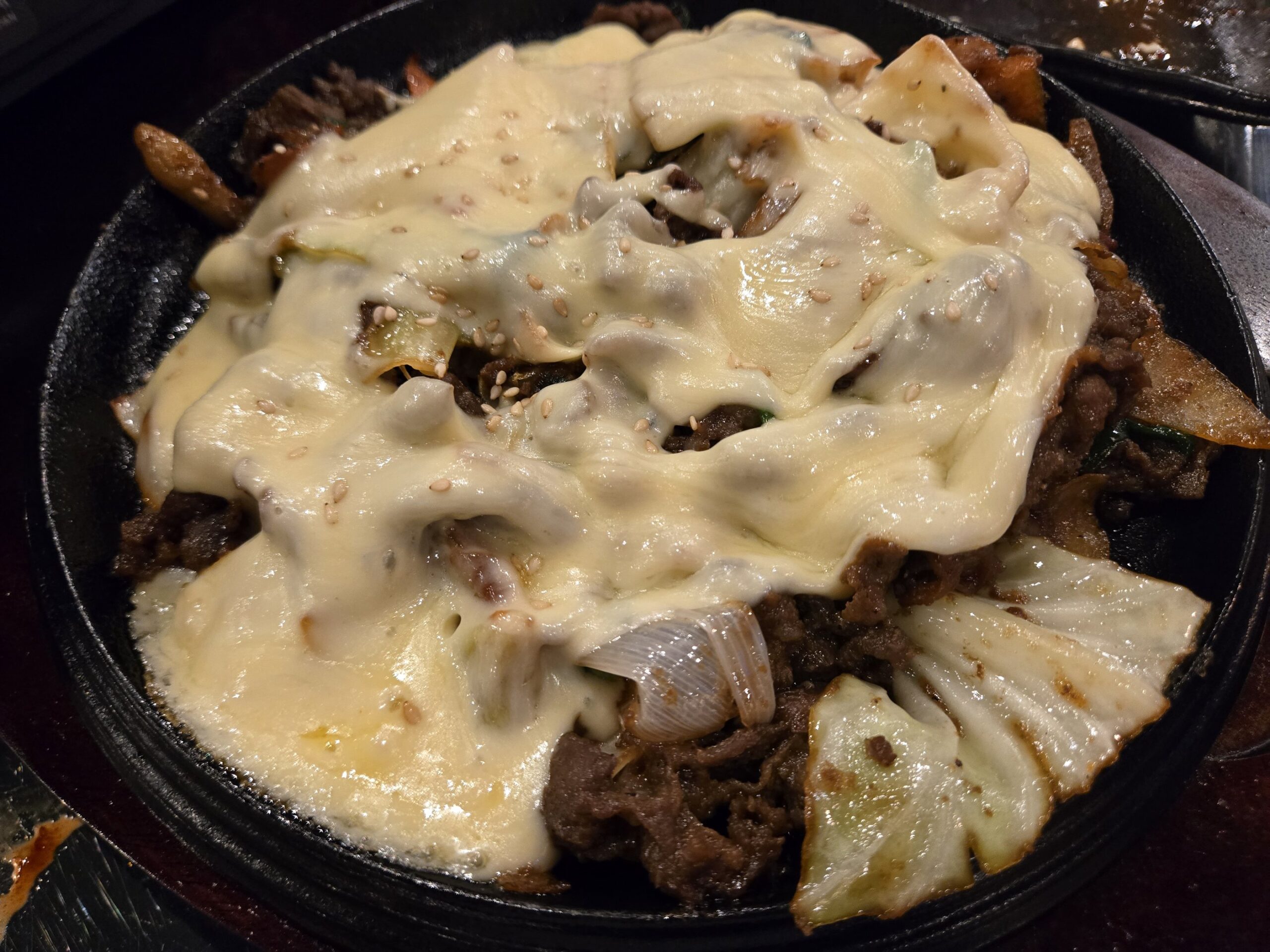 チーズがかかった鉄板のお肉料理