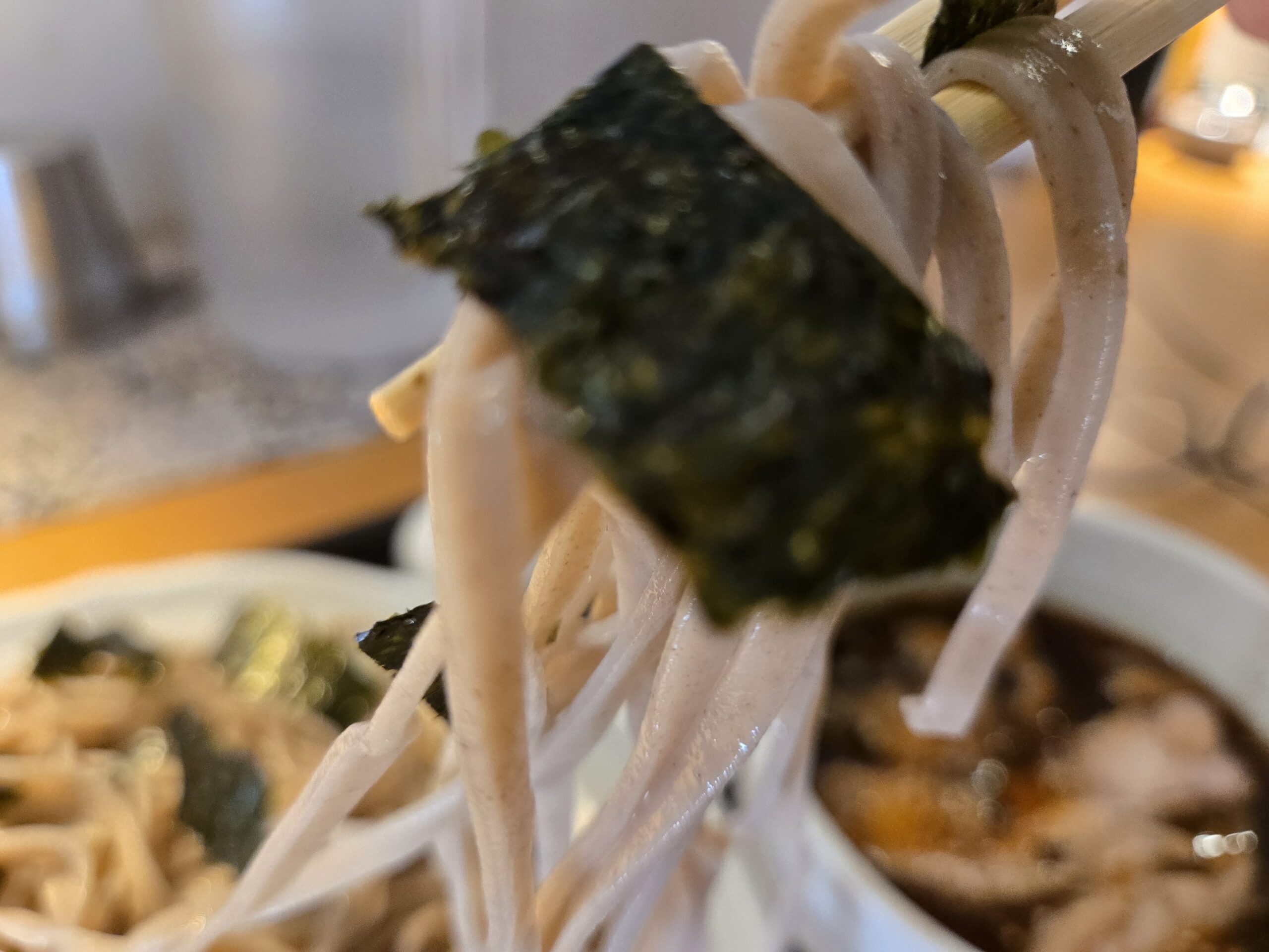 海苔が乗ったそばを持ち上げる様子