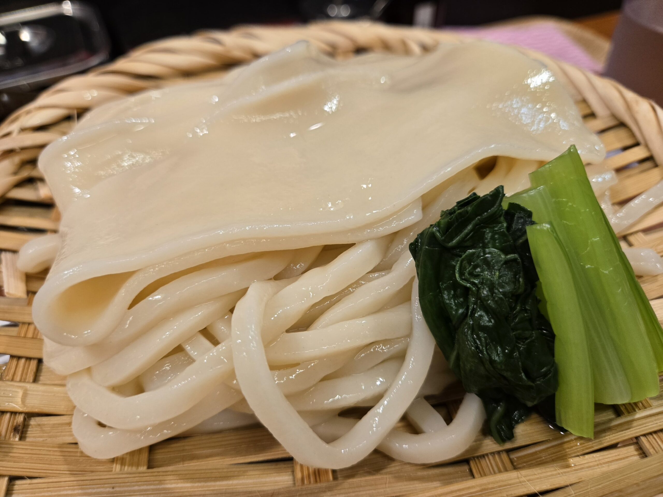 ざるに盛られたうどんとほうれん草