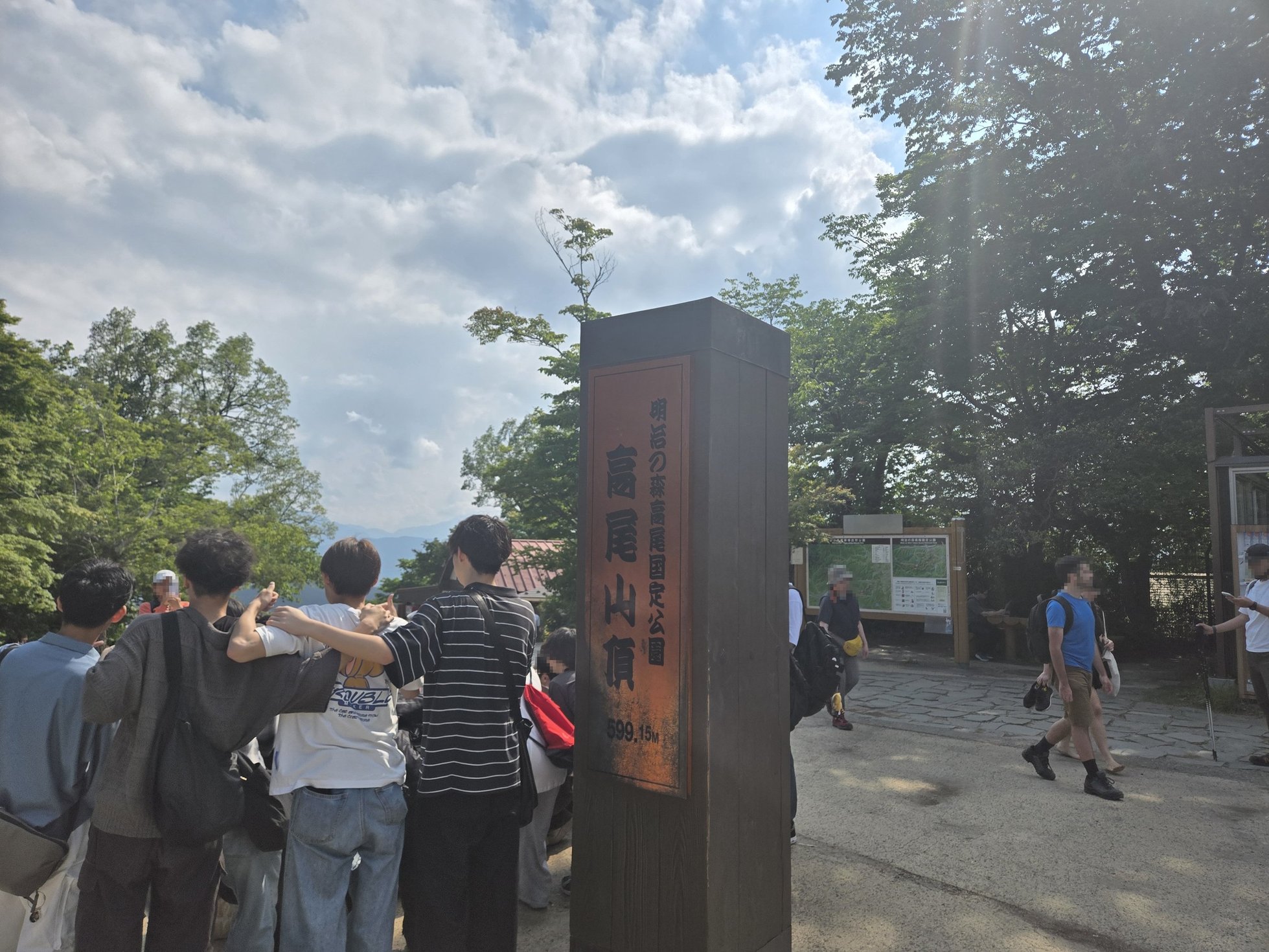高尾山登山口に集まる人々と看板