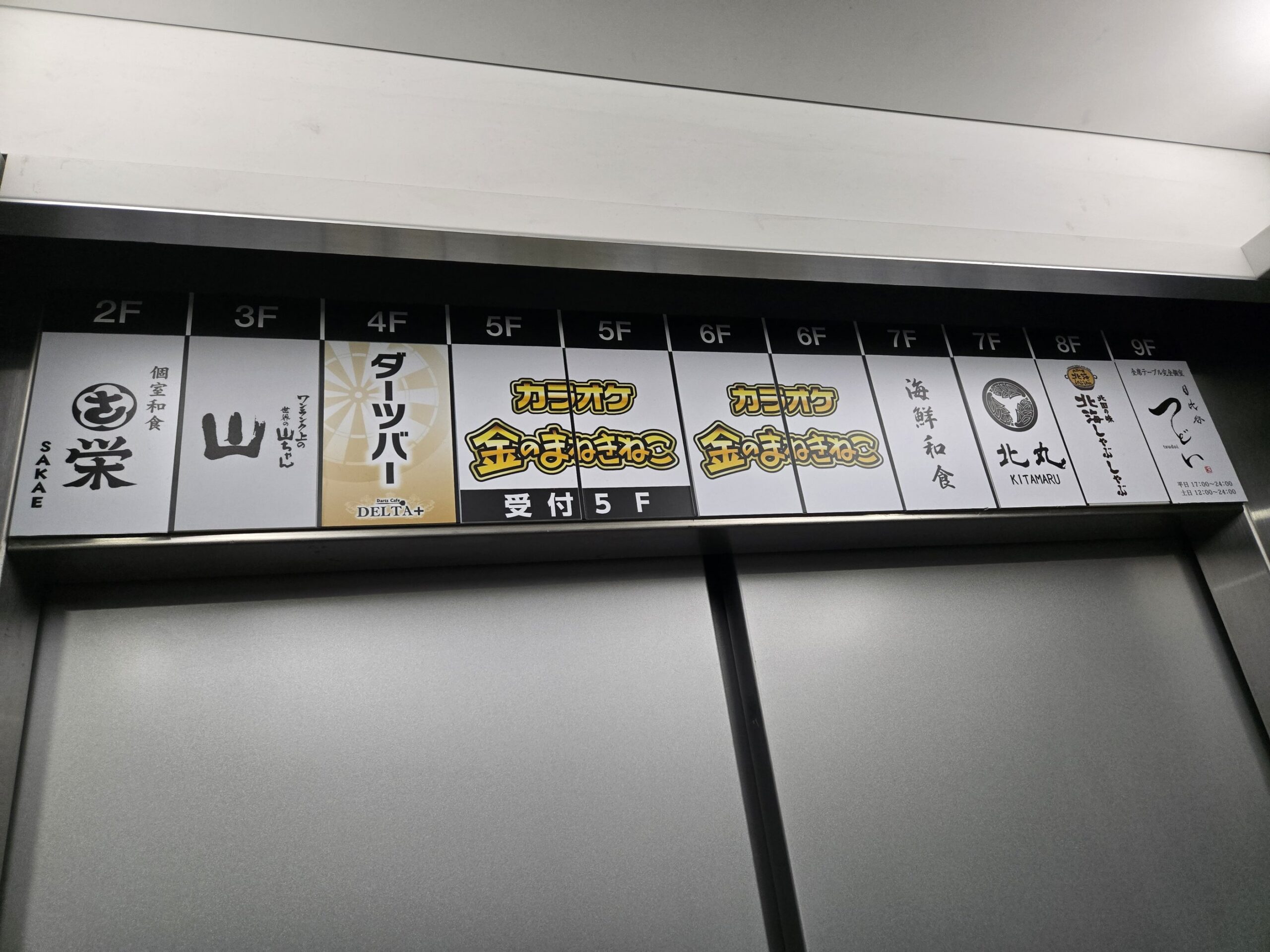「つどい 日比谷」のあるビルのエレベーター内の店舗案内サイン
