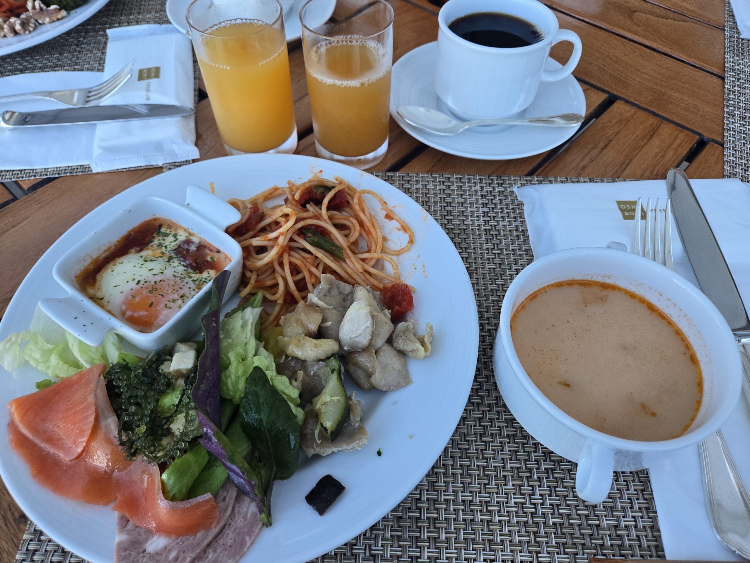 朝食プレートと飲み物、ジュースとコーヒーが並ぶ