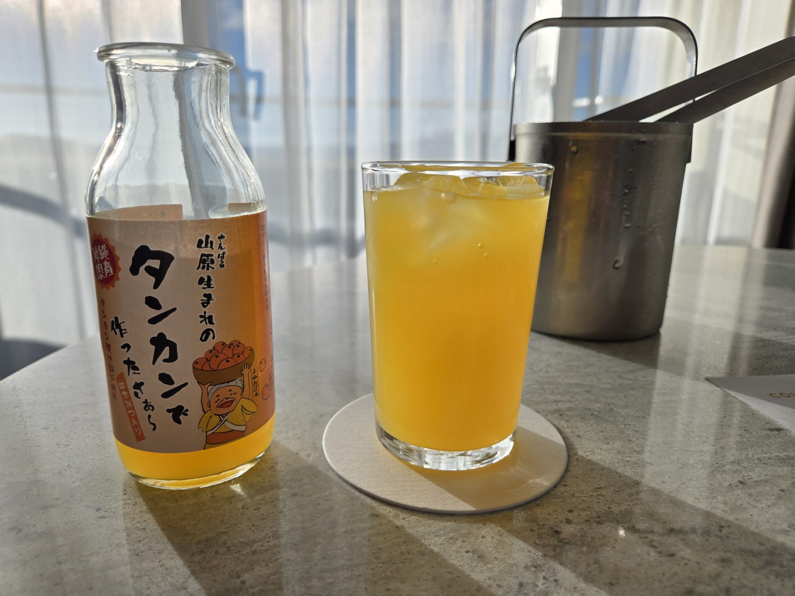 タンカンジュースと氷の入ったグラス