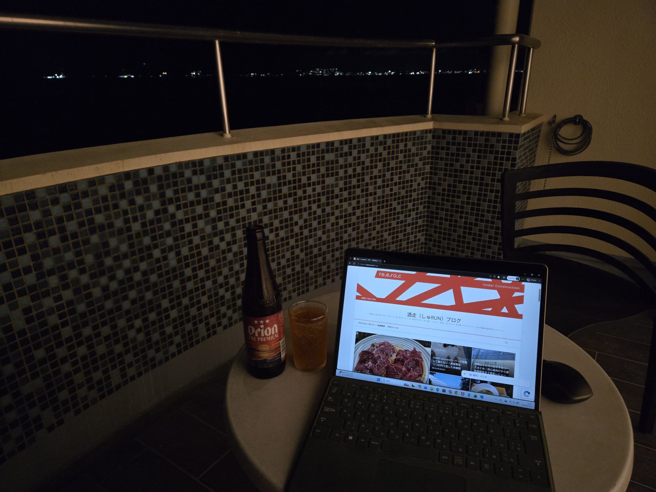 バルコニーからの夜景とビール、ノートPC