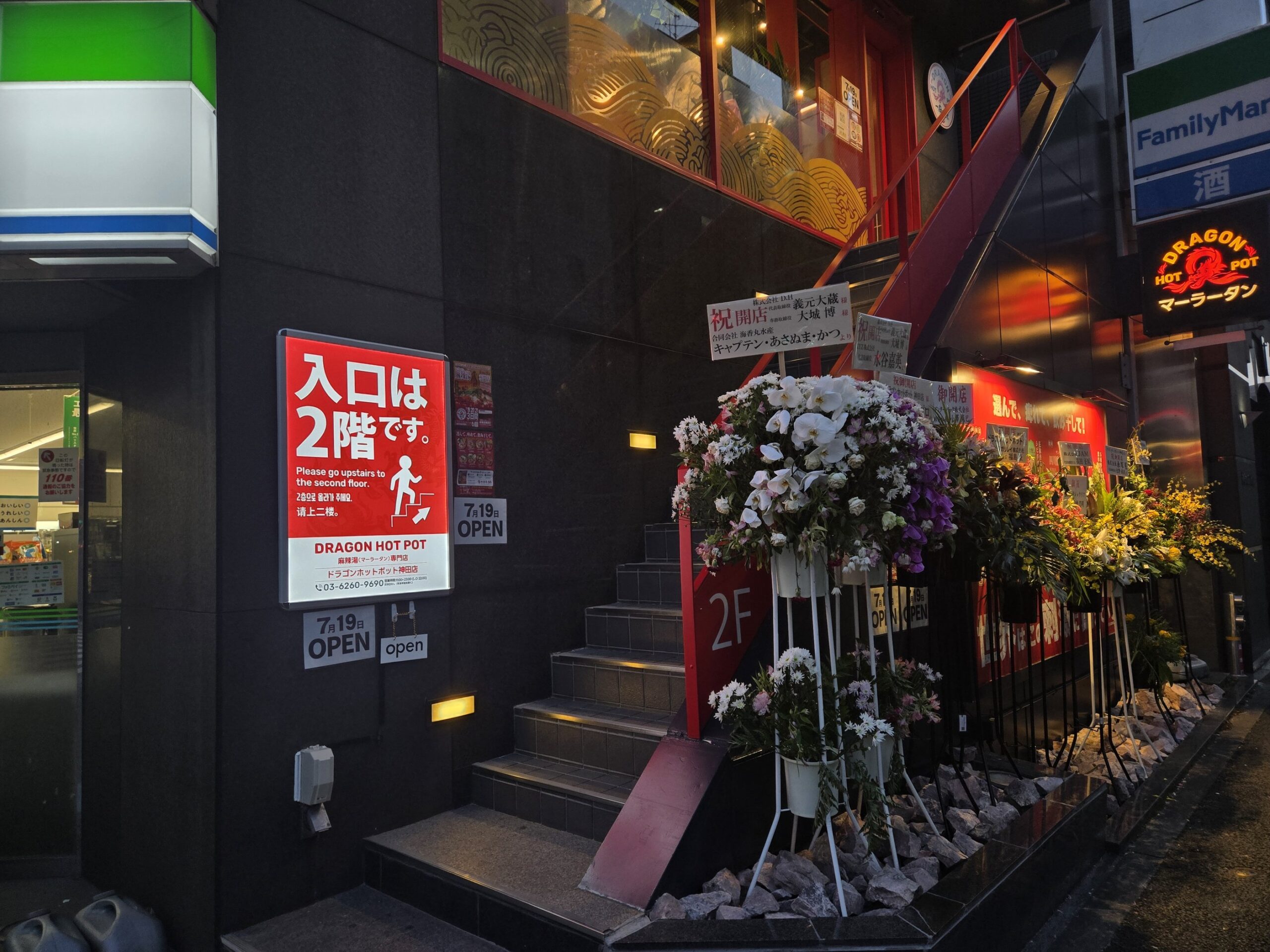 ドラゴンホットポット神田店の入口案内、開店祝いの花