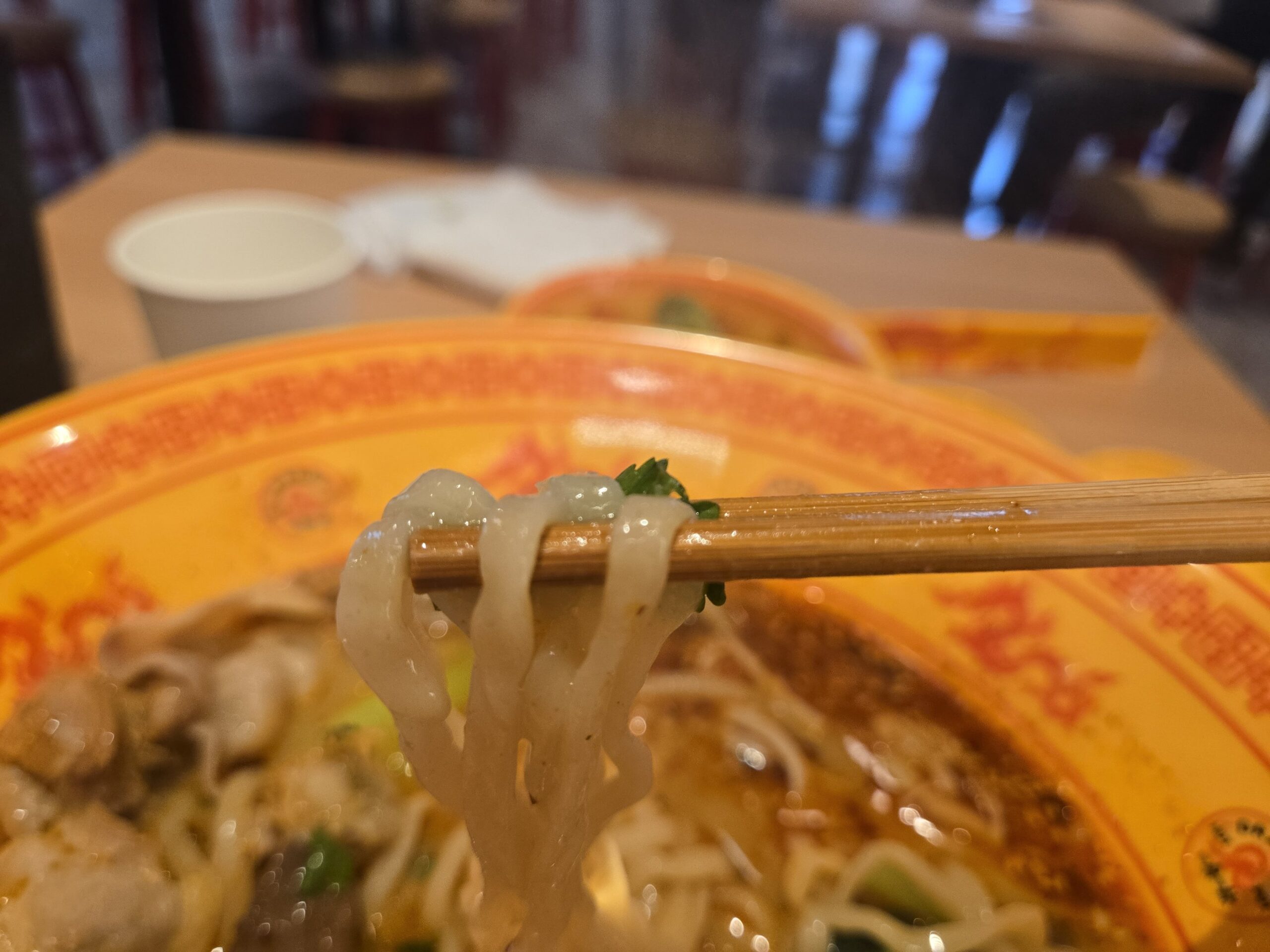 箸と麺、トッピングが絡む
