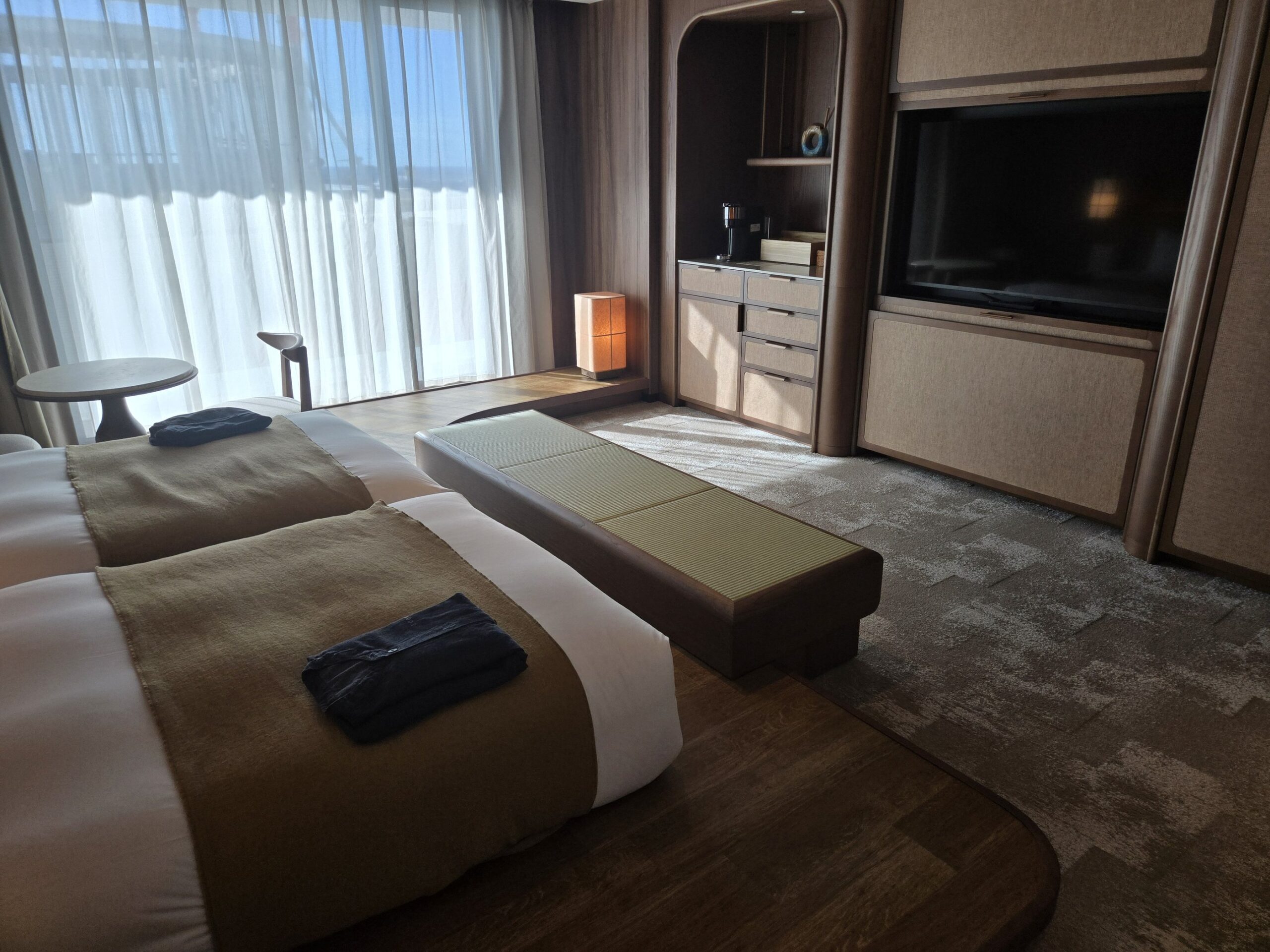 大きなベッドと自然光が差し込むホテルの部屋
