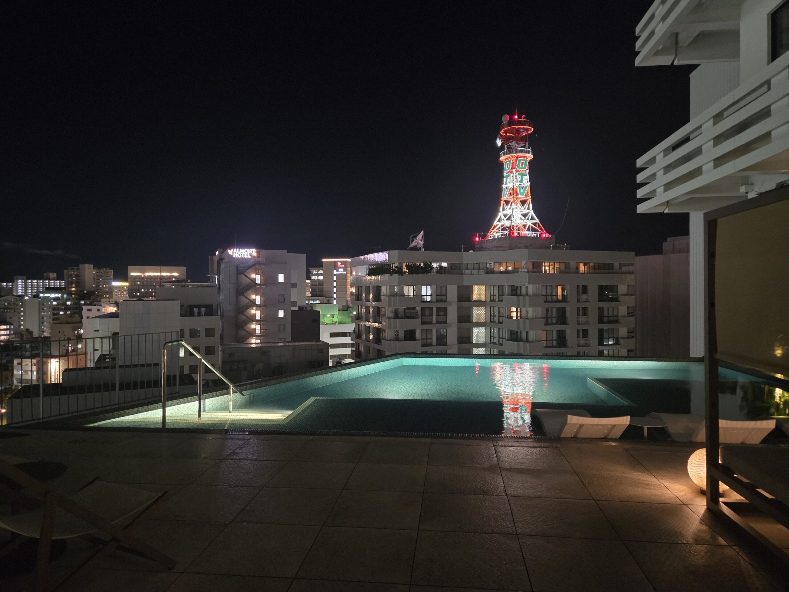 夜のプールとイルミネーションされたタワーの遠景