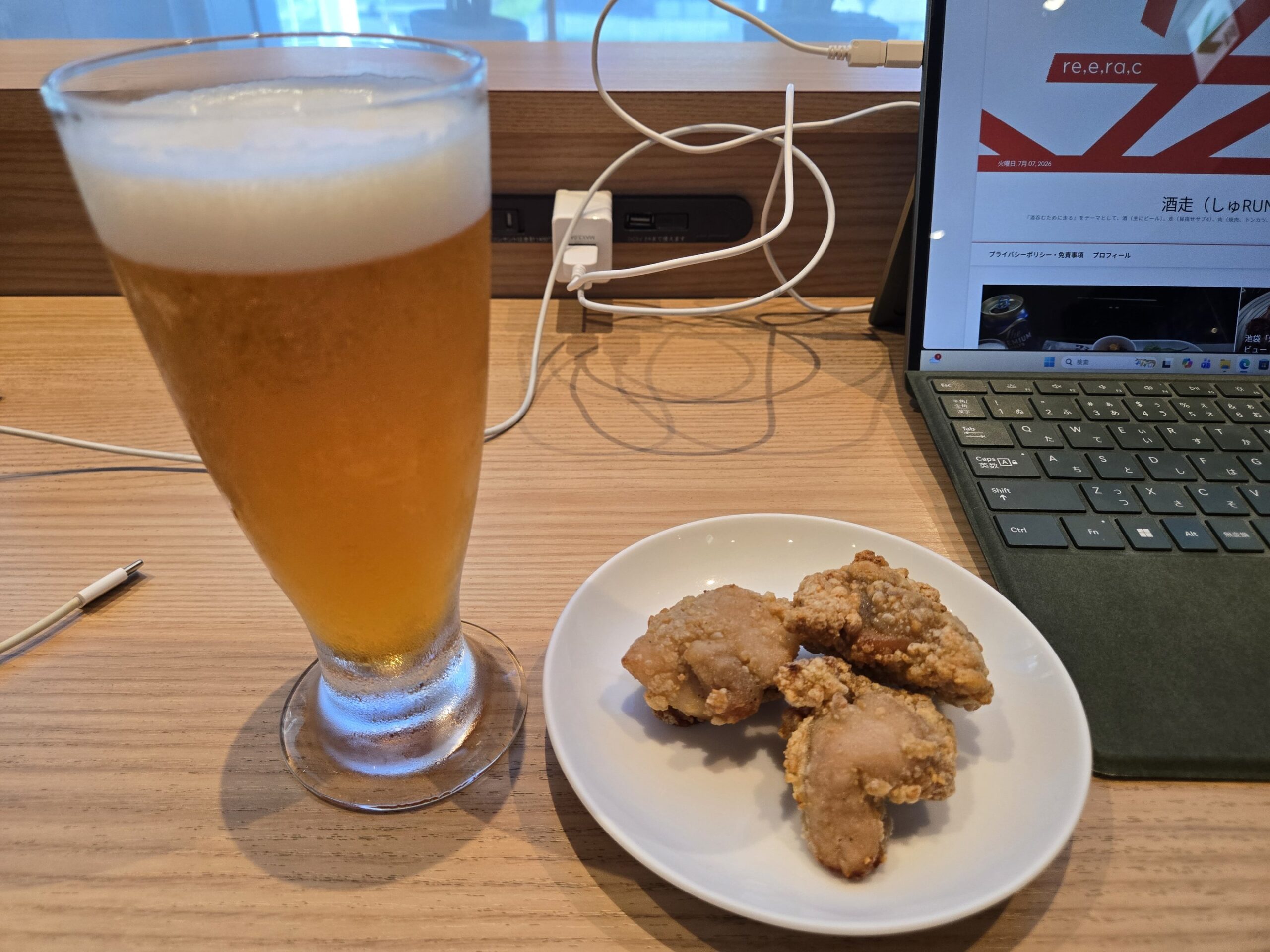 ラウンジの座席でビールとから揚げがテーブルに置かれている