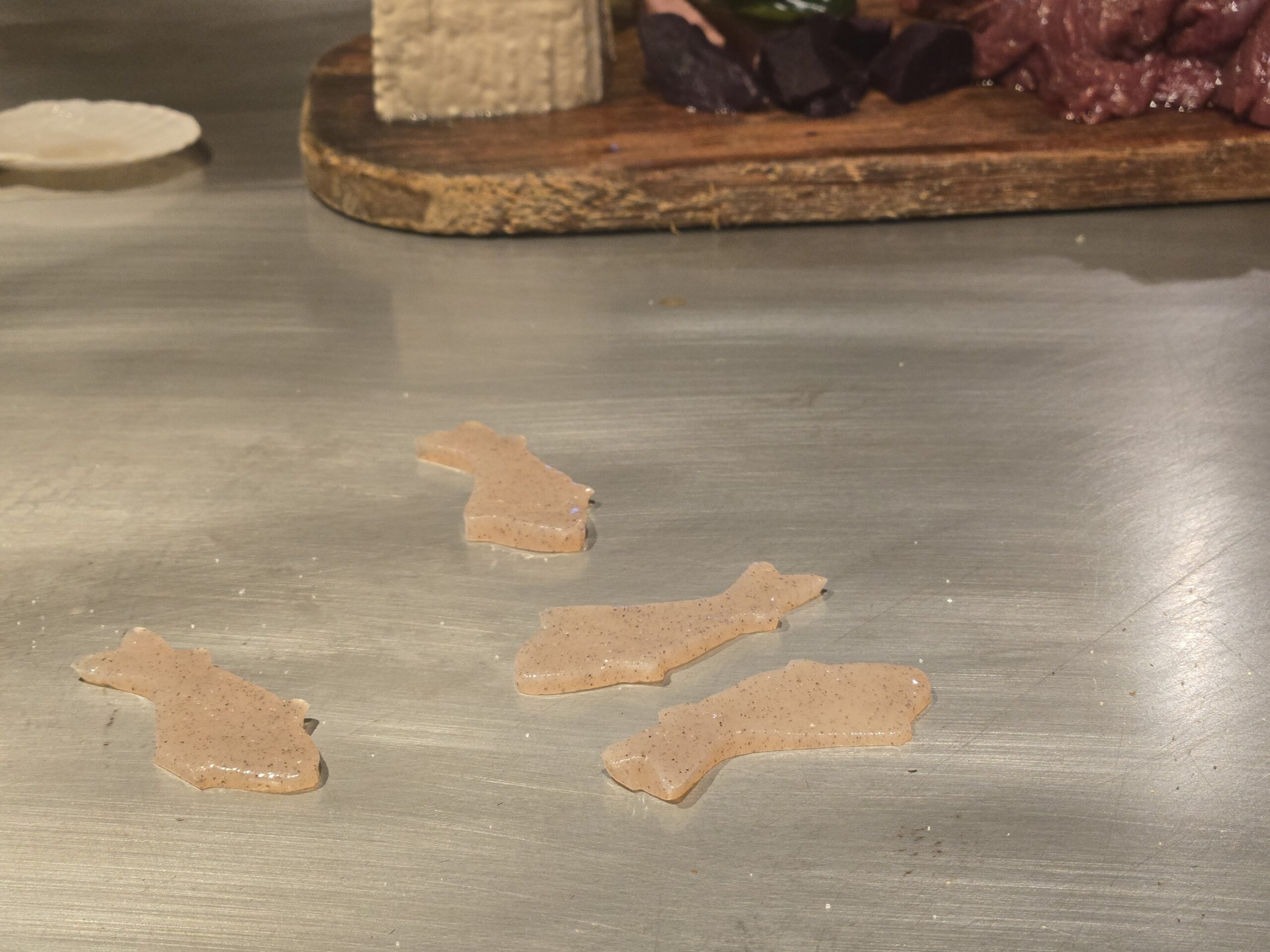 鉄板に置かれたユニークな魚の形をしたコンニャク