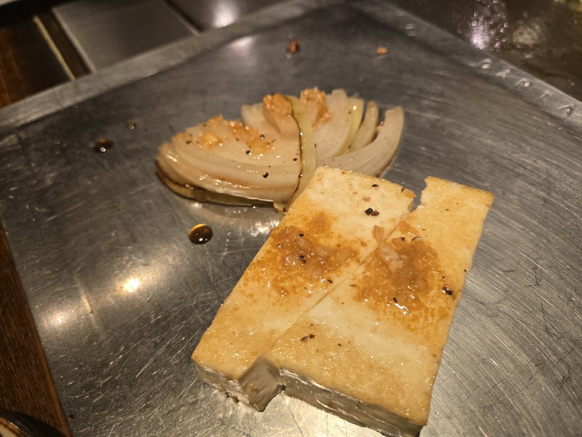 鉄板で焼かれた島豆腐と玉ねぎ
