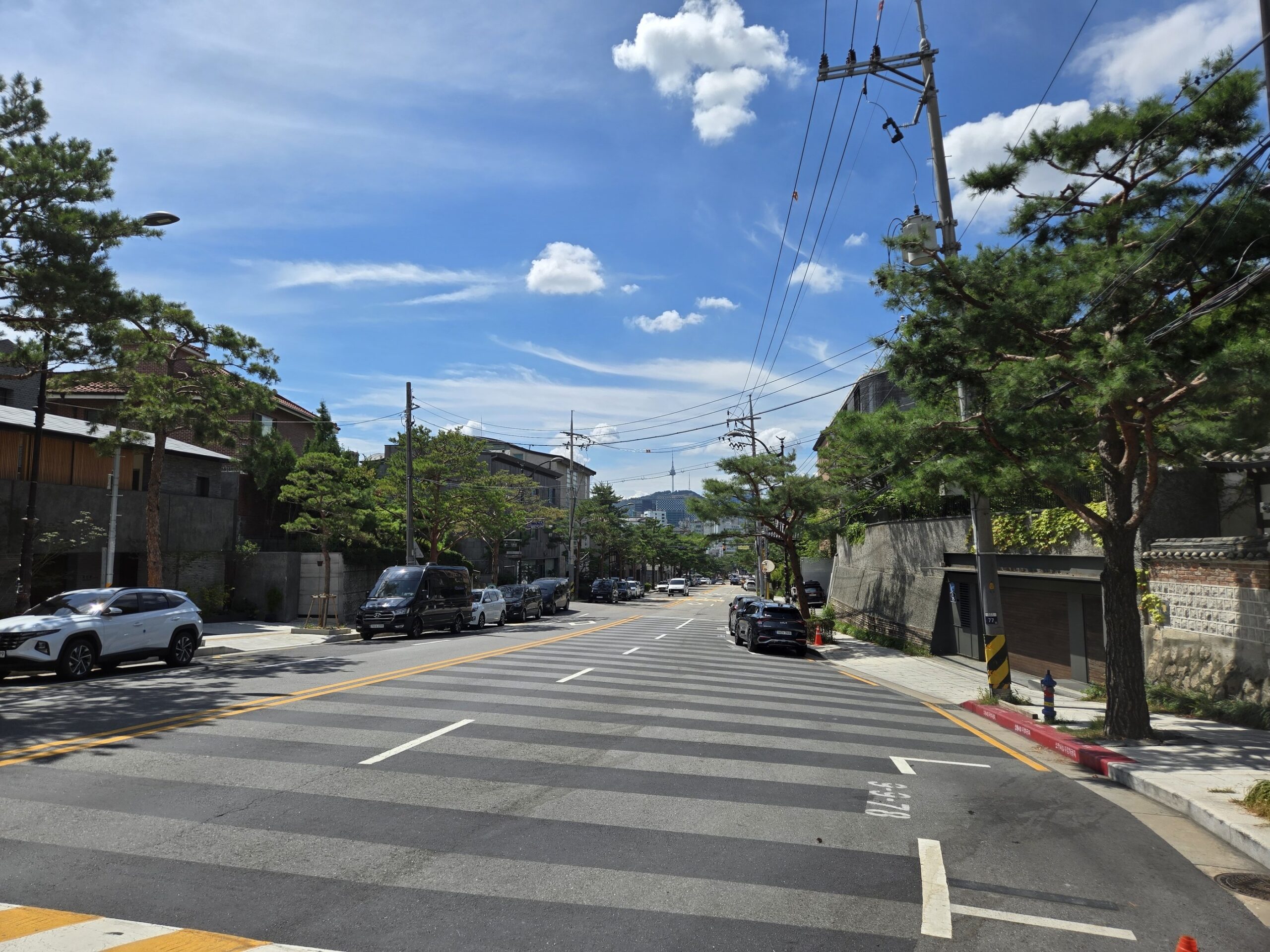 広い道路と並木、晴れた空と雲