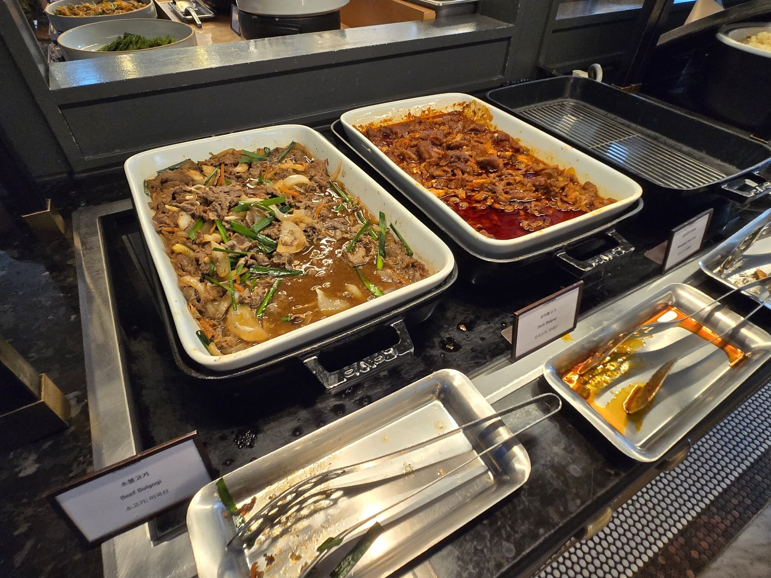 ビュッフェの肉と野菜の炒め物が並ぶトレイ