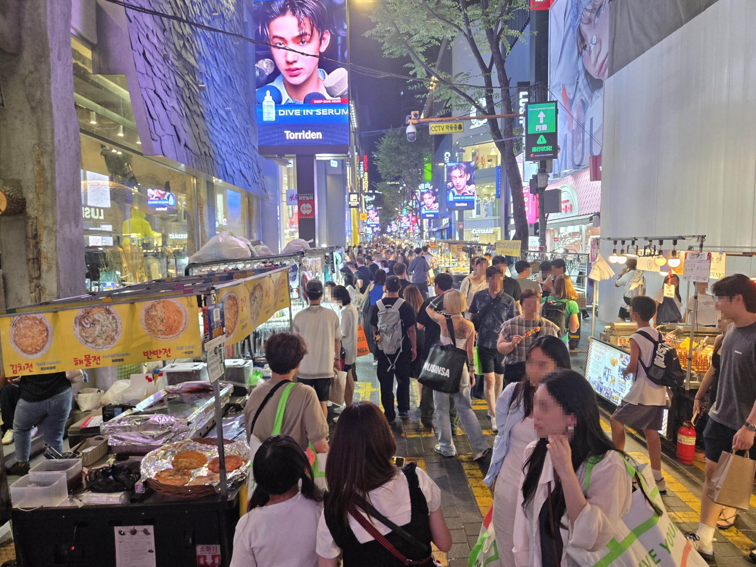 ソウル明洞の夜の屋台通り、人々が食事や買い物を楽しむ