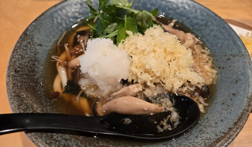 具だくさんの温かいうどん、大根おろしやキノコ