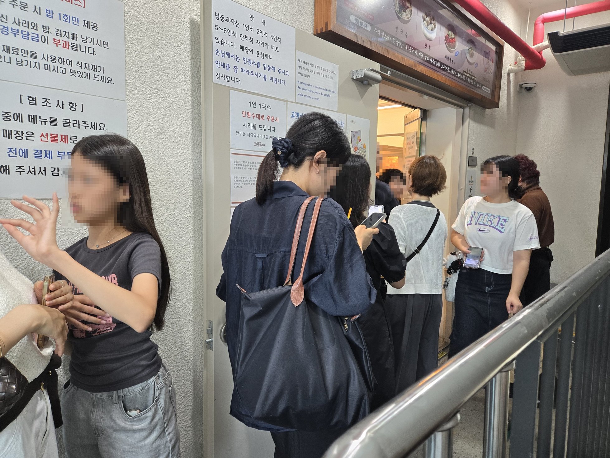レストランの入口の前で並ぶ人々